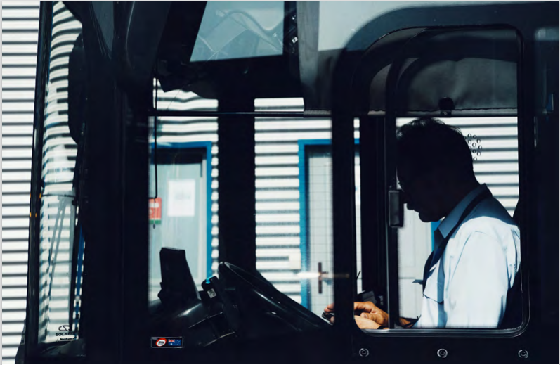 A man in the driver's seat of a bus